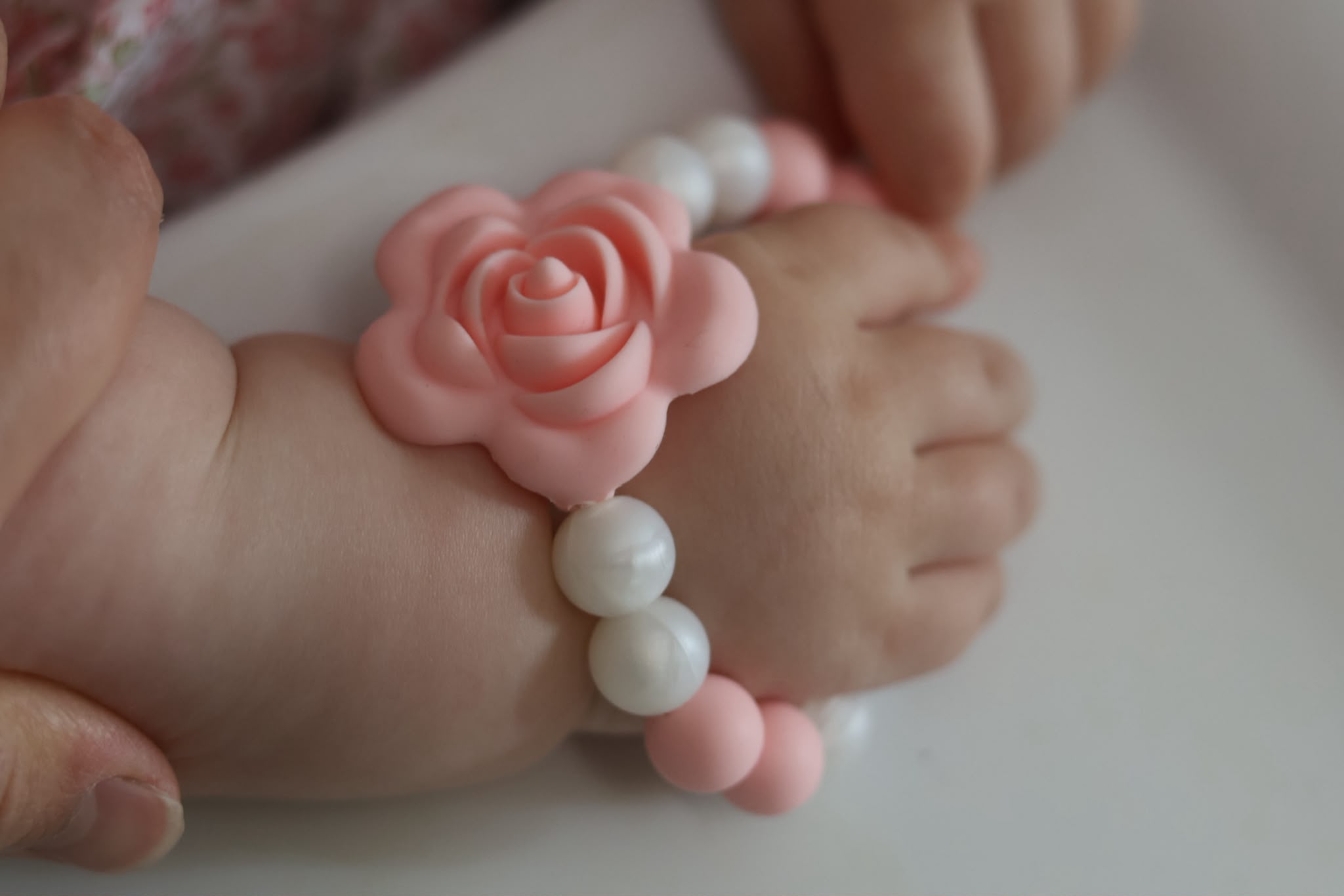 Détail d'un bracelet fleuri sur la main d'un bébé