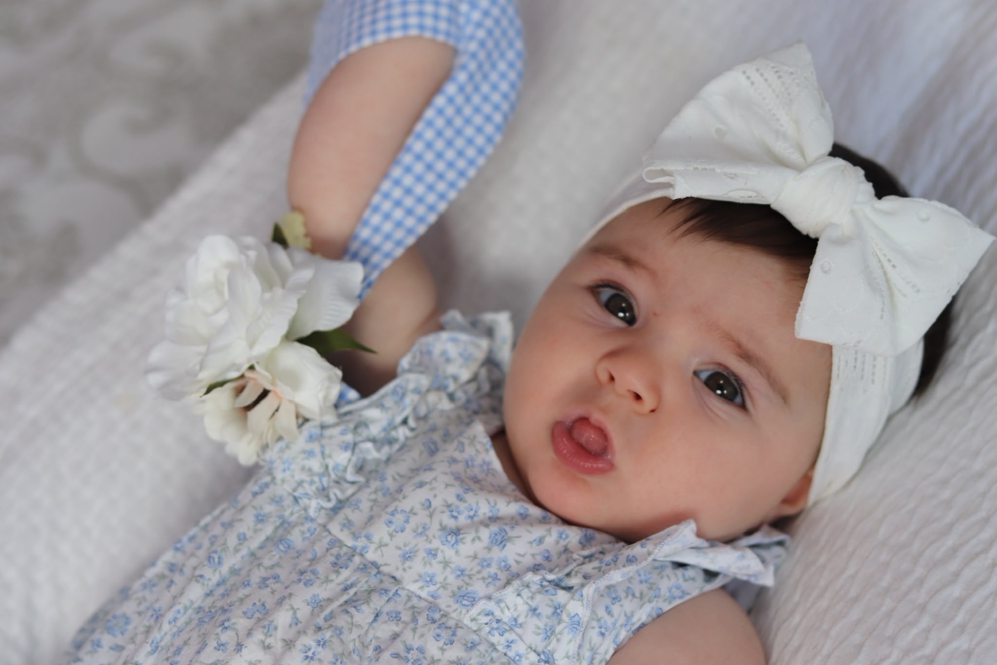 Bébé avec un nœud blanc et une fleur